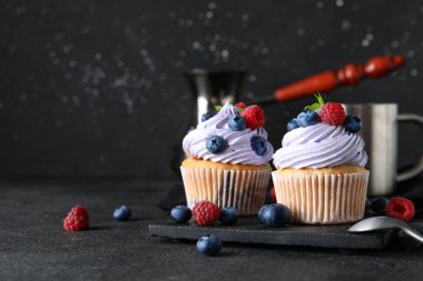 Böğürtlenli, ahududulu ve siyah arkaplanlı lezzetli kekler.