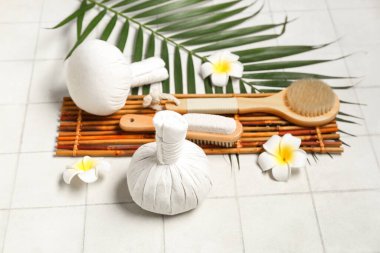 Kaplıca aksesuarları, palmiye yaprağı ve açık fayanslı tropikal çiçekli kompozisyon