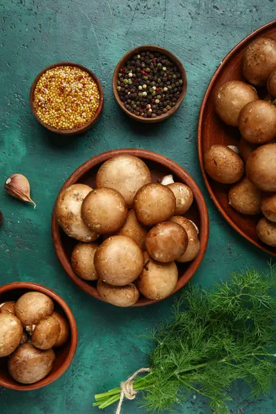 Taze mantarlı kaseler ve yeşil arka planda farklı baharatlar.