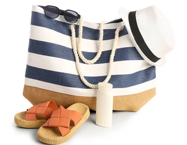 Beyaz arka planda izole edilmiş plaj aksesuarlarıyla bir şişe güneş kremi.