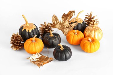 Altın külahlı balkabakları ve beyaz arkaplanda yaprakları