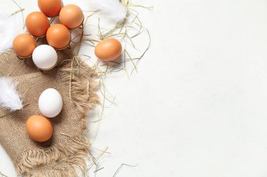 Beyaz arka planda çiğ tavuk yumurtası ve çuval bezi olan tutucu.