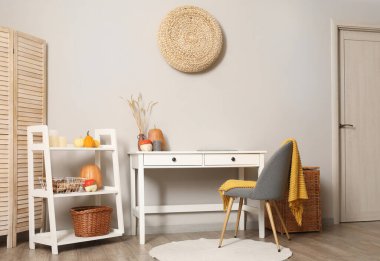 Rahat iş yerleri ve balkabaklarıyla modern oturma odasının içinde.