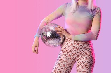 Renkli arka planda disko topu olan güzel genç kadın, yakın plan.