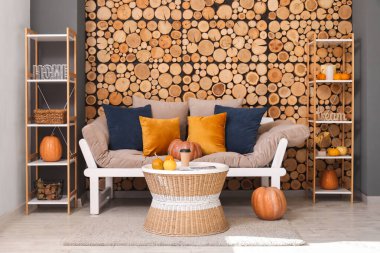 Kanepesi, sehpası ve balkabağı olan rahat bir oturma odasının sonbaharı.