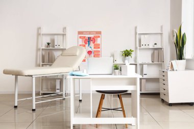 Çalışma yeri, kanepe ve raf üniteleri olan bir tıp bürosu.