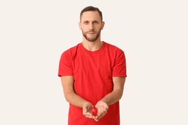 Beyaz arka planda kırmızı kurdeleli genç adam. AID farkındalık kavramı