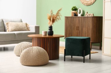 İçinde kahve masası ve puf olan modern oturma odası.