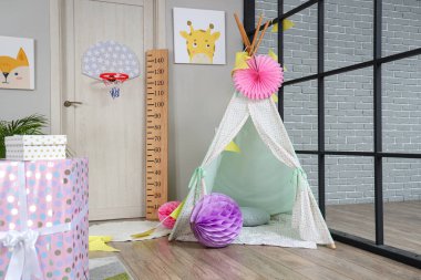 Doğum günü için dekore edilmiş çocuk odasında rahat oyun çadırı olan hediye kutuları