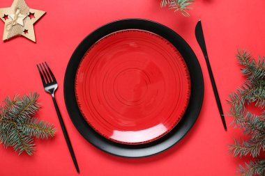 Kırmızı arka planda Noel ağacı dalları olan güzel bir masa.