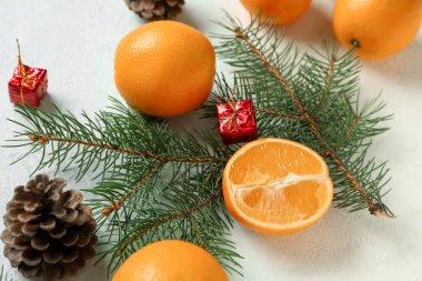 Köknar dallı lezzetli portakallar, çam kozalağı ve açık mavi arka planda hediye kutuları.