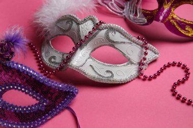 Pembe arka planda karnaval maskeleri
