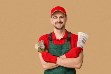 Arkaplanda fırça ve renk paletleri olan erkek ressamın portresi