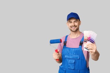 Boya silindirli erkek ressamın portresi ve gri arka planda renk paletleri