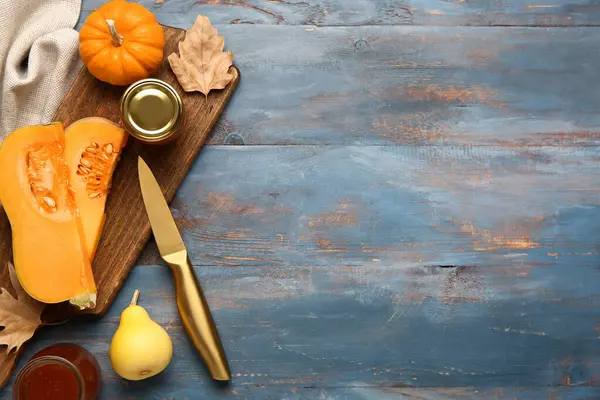 Kavanozlar dolusu tatlı balkabağı reçeli ve mavi ahşap arka planda armut