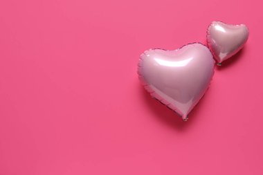 Pembe arka planda kalp şeklinde hava balonları. Sevgililer Günü kutlaması