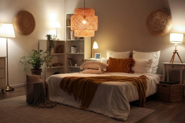 Rahat yatak odası, battaniye ve geceleri parlayan lambalar.