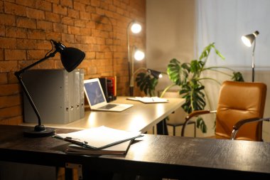 Geceleri karanlık ofisteki masada panosu olan lamba, yakın plan.