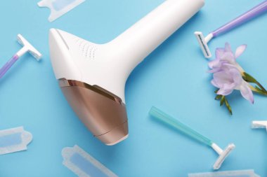 Mavi arka planda balmumu şeritli, jiletli ve güzel çiçekli modern fotoepilatör.