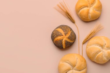 Lezzetli kayzerler ve bej arka planda buğday kulakları.