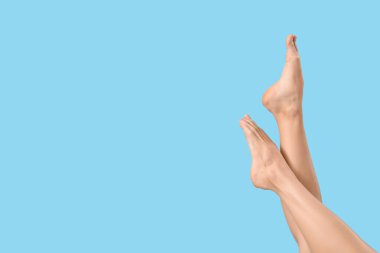 Mavi arka planda çıplak ayaklı kadın.