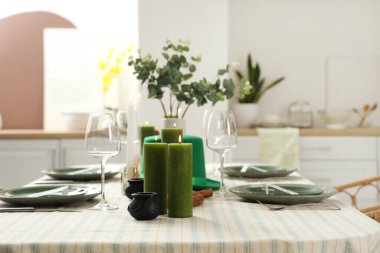 Yemek odasında cüce şapkası ve yanan mumlarla servis edilen şenlik masası. Aziz Patrick Günü kutlaması