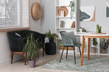 Modern oturma odası, siyah kanepe, masa ve raf ünitesi.