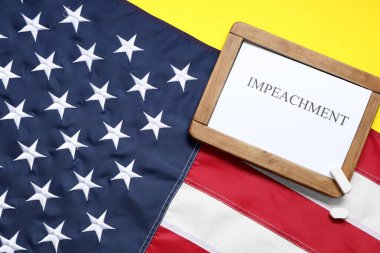 Sarı arka planda IMPEACH ve ABD bayrağı bulunan tebeşir tahtası