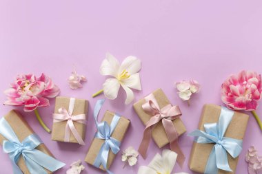 Şenlikli hediye kutuları ve pembe arka planda güzel çiçekler