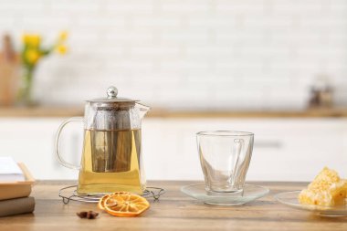 Mutfaktaki masada çaydanlık yeşil çay ve boş bardak.