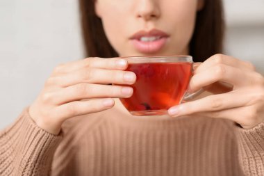 Elinde bir fincan çay tutan genç ve güzel bir kadın. Yakın çekim.