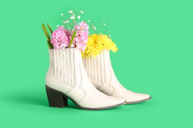 Yeşil arka planda çiçekli beyaz çizmeler