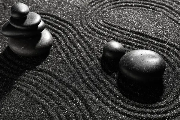 Japon kaya bahçesinde çizgileri olan koyu kumdaki taşlar. Zen kavramı