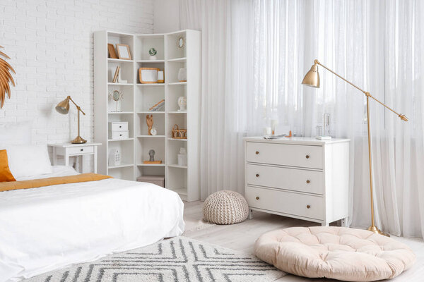 Интерьер светлой спальни с полками и ящиками