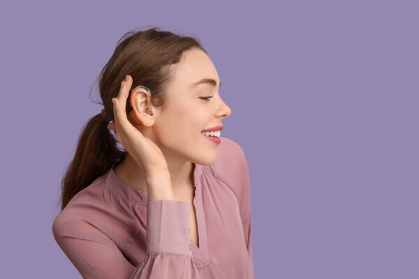 Красивая молодая женщина со слуховым аппаратом на фоне сирени