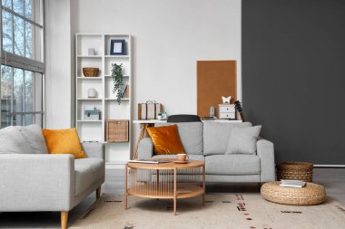 Kanepeleri, kahve masası ve yastıkları olan modern bir oturma odası.