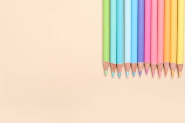 Bej arkaplanda renkli kalemler seti