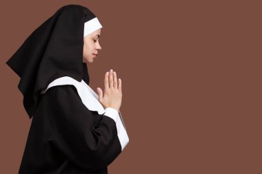 Kahverengi arka planda dua eden genç bir rahibe