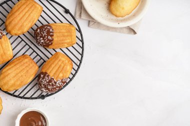 Çikolata kremalı ve beyaz arka planda hindistan cevizi taneli leziz madeleine sahip ızgara.