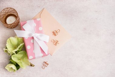 Güzel çiçekli hediye kutusu, beyaz arka planda zarf ve mum.