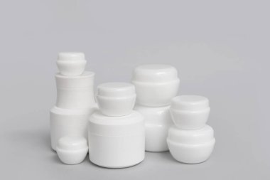 Gri arka planda kozmetik ürünlerin kavanozlarıyla kompozisyon