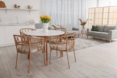 Modern mutfağın içinde yemek masasında lale vazosu olan bir vazo.