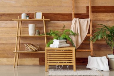 Banyonun içinde raf ünitesi ve temiz havlular var.