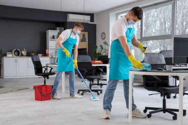 Temizlik işçisi erkek işçiler ofiste dezenfekte ediliyor