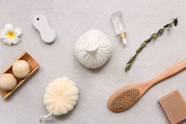 Bitkisel poşetli spa kompozisyonu, banyo süngeri, masaj vücut fırçası, ahşap masaj topları, grunge arka planında bir şişe gerekli yağ ve sabun.