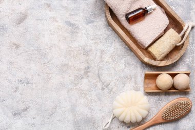 Masaj fırçası, banyo süngeri, ahşap tepsi, havlu, lif ve arkaplanda ahşap masaj topları.