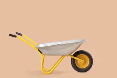 Bej arkaplanda boş el arabası