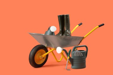 Turuncu arka planda bahçe aletleri ve el arabası