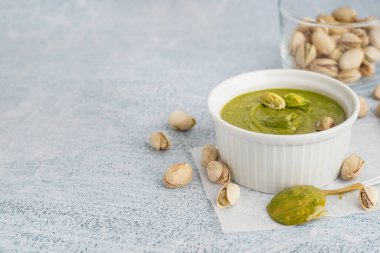 Beyaz grunge arka planda fıstık ezmeli kase ve kaşık.