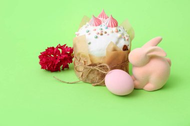 Paskalya pastası, boyanmış yumurta, yeşil arka planda tavşan ve sümbül, yakın plan.
